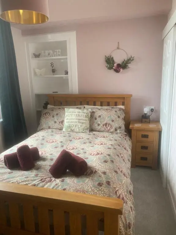 a bedroom with a bed with two pillows on it at Butterfly Apartment in Inverness