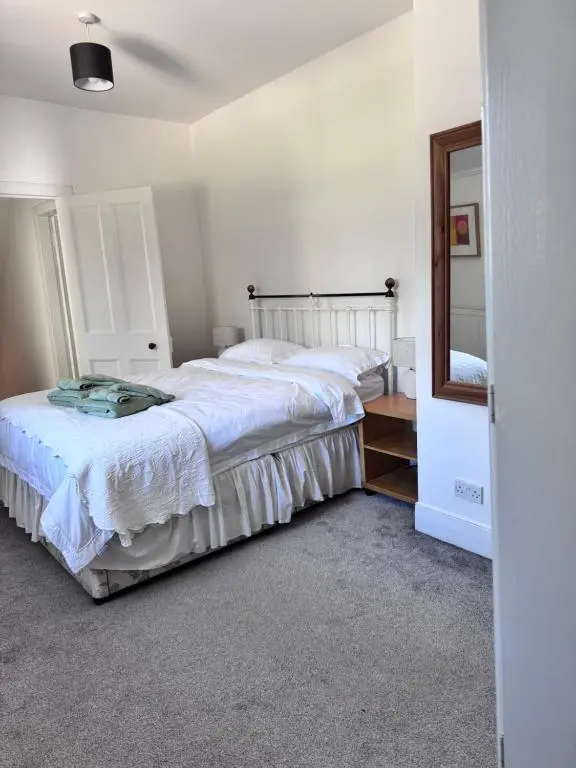 a bedroom with a large bed and a mirror at 19th century 5-bedroom villa with free private parking in Elgin