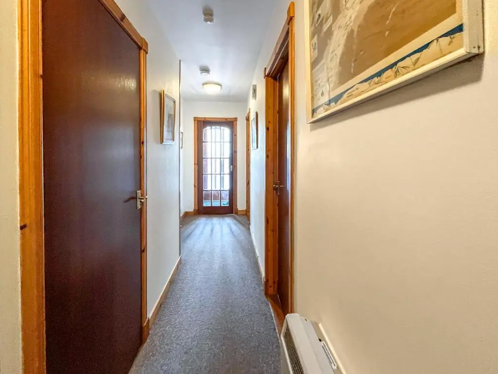 a hallway with a door and a hallwayngthngthngthngthngthngthngthngth at Heath Cottage in Boat of Garten
