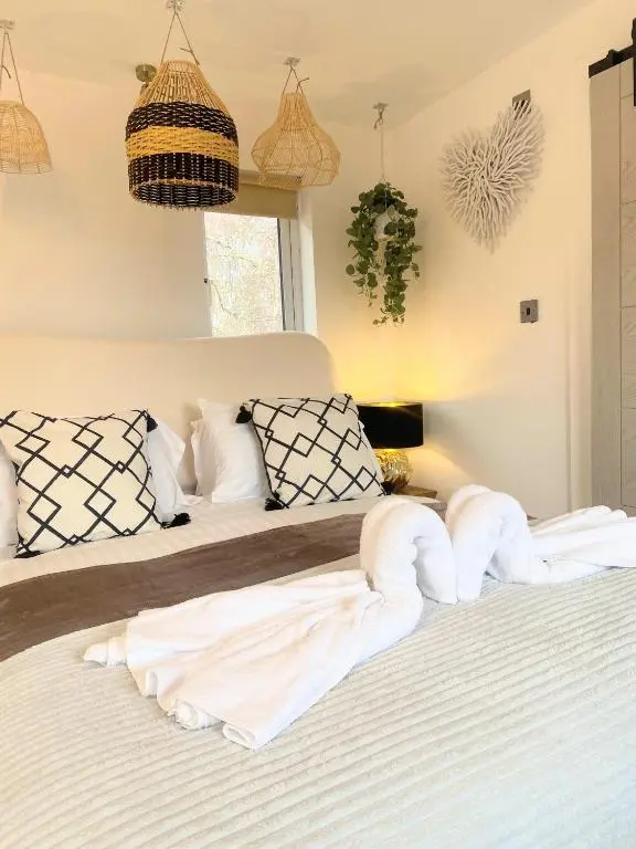 a bedroom with a bed with white sheets and pillows at Kaoglen - Bali Pod - Hot Tub -Cairngorms - Pitlochry in Kirkmichael