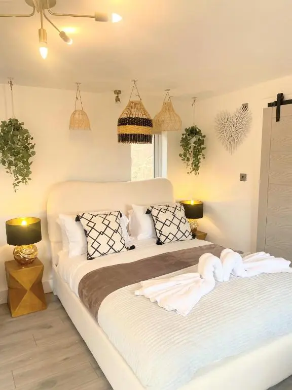 a bedroom with a large bed with towels on it at Kaoglen - Bali Pod - Hot Tub -Cairngorms - Pitlochry in Kirkmichael
