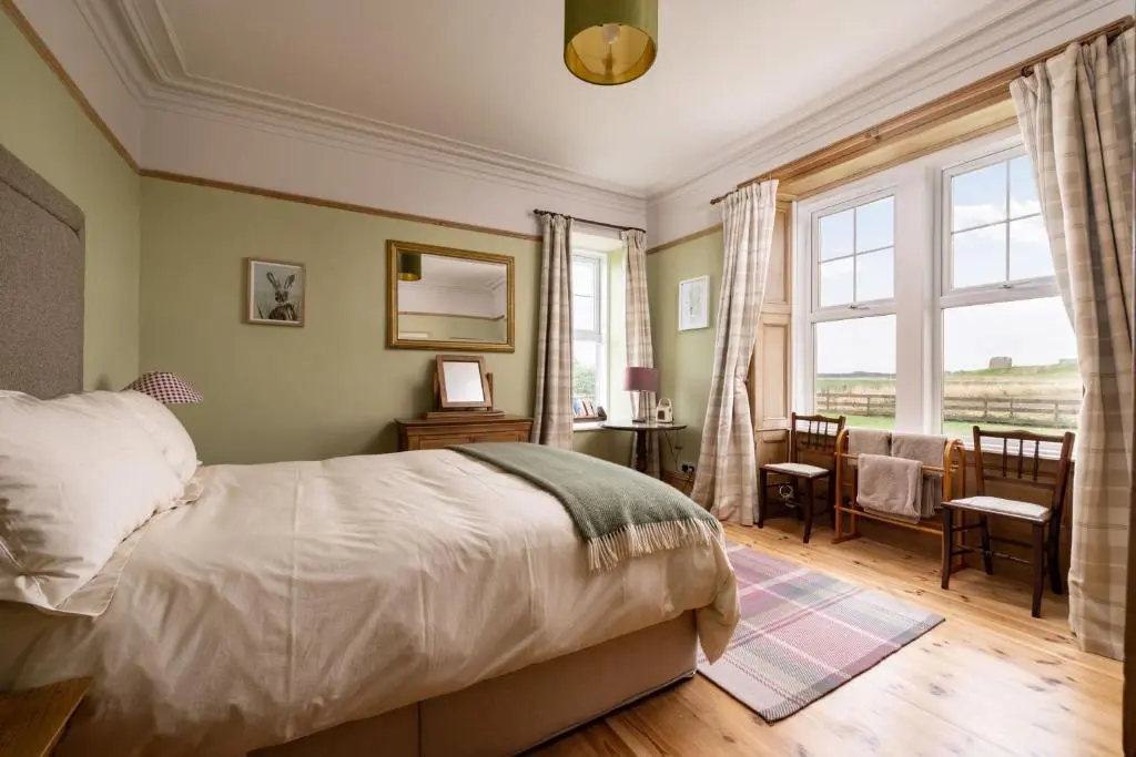 a bedroom with a bed and a desk and a window at Old Duffus Farmhouse in Duffus