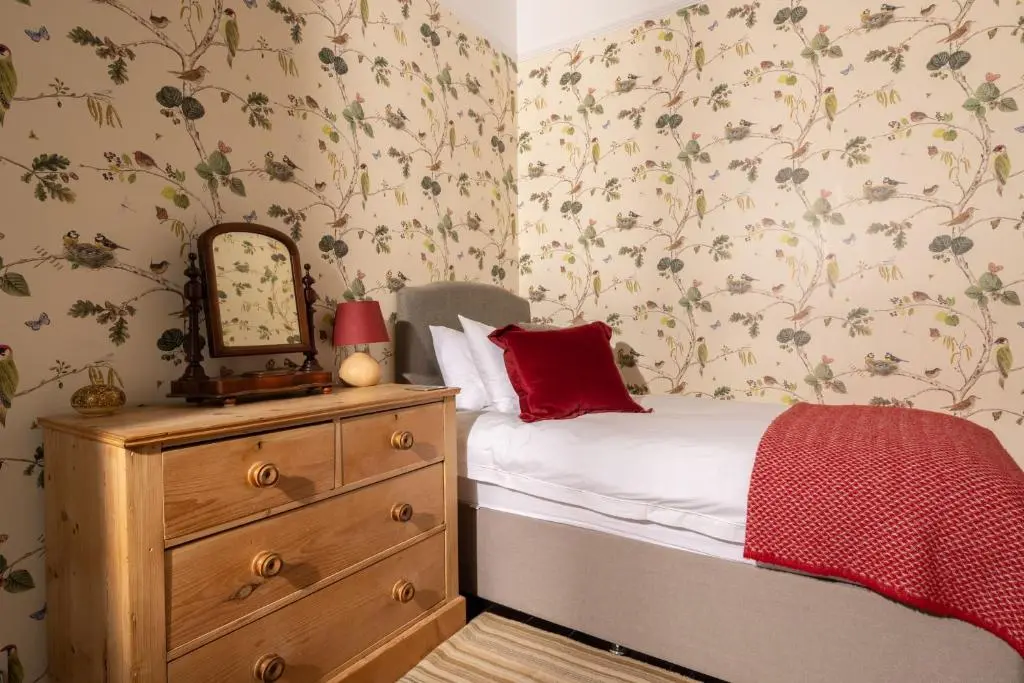a bedroom with a bed and a dresser with a mirror at Duffus House Lodge in Duffus