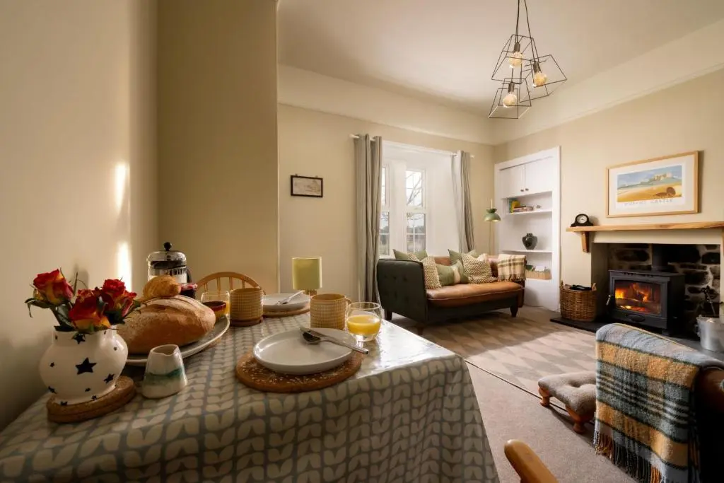 a living room with a table and a fireplace at Duffus House Lodge in Duffus