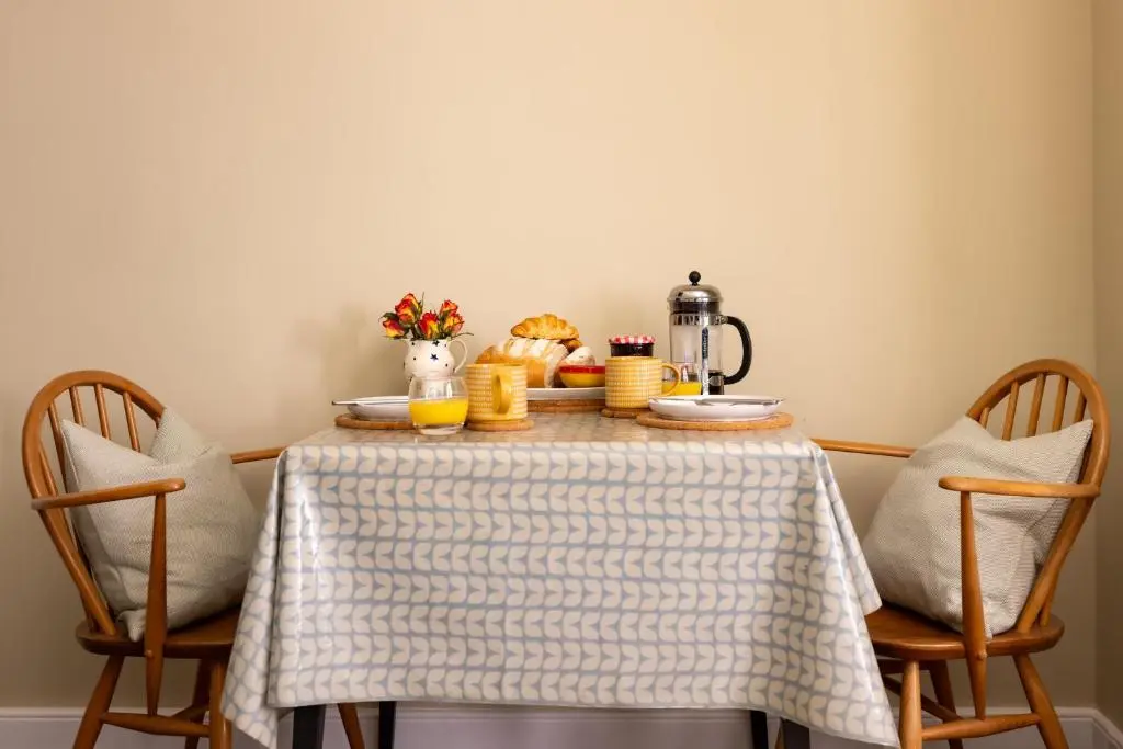 a table with a breakfast of bread and orange juice at Duffus House Lodge in Duffus