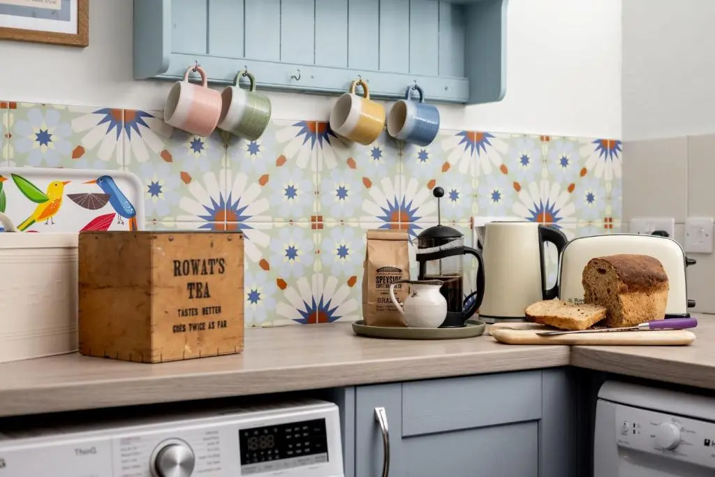 a kitchen with a counter top with coffee cups and bread at Kirktoun Cottage in Duffus