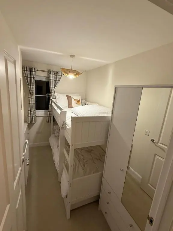 a small room with a bunk bed and a mirror at Loch Ness Hideaway in Inverness