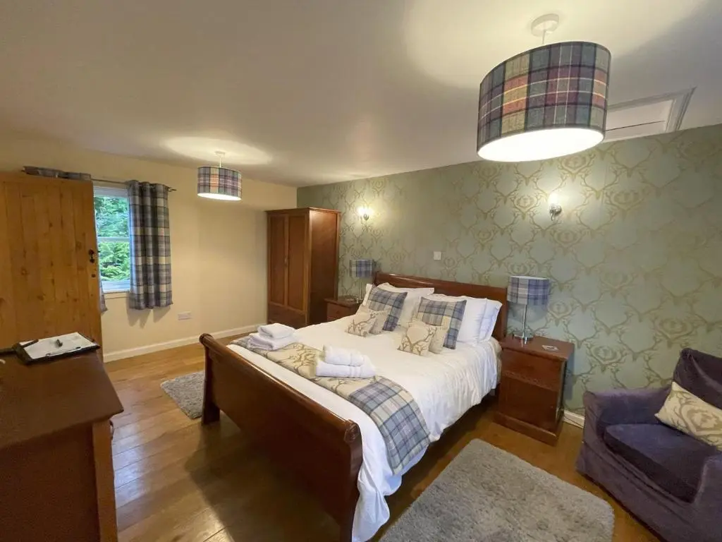 a bedroom with a bed and a couch in it at Groose Hoose in Glenshee