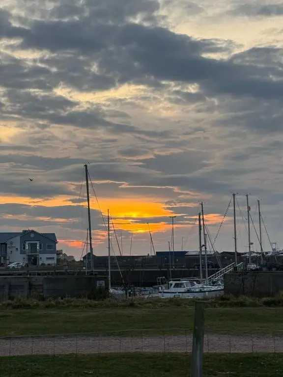 a group of boats docked in a harbor at sunset at Agnes Place in Nairn