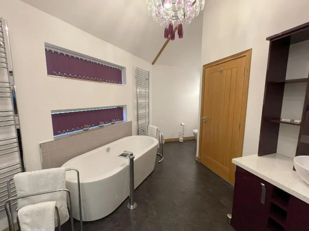 a bathroom with a tub and a sink at Scots Pine Treehouse in Glenshee