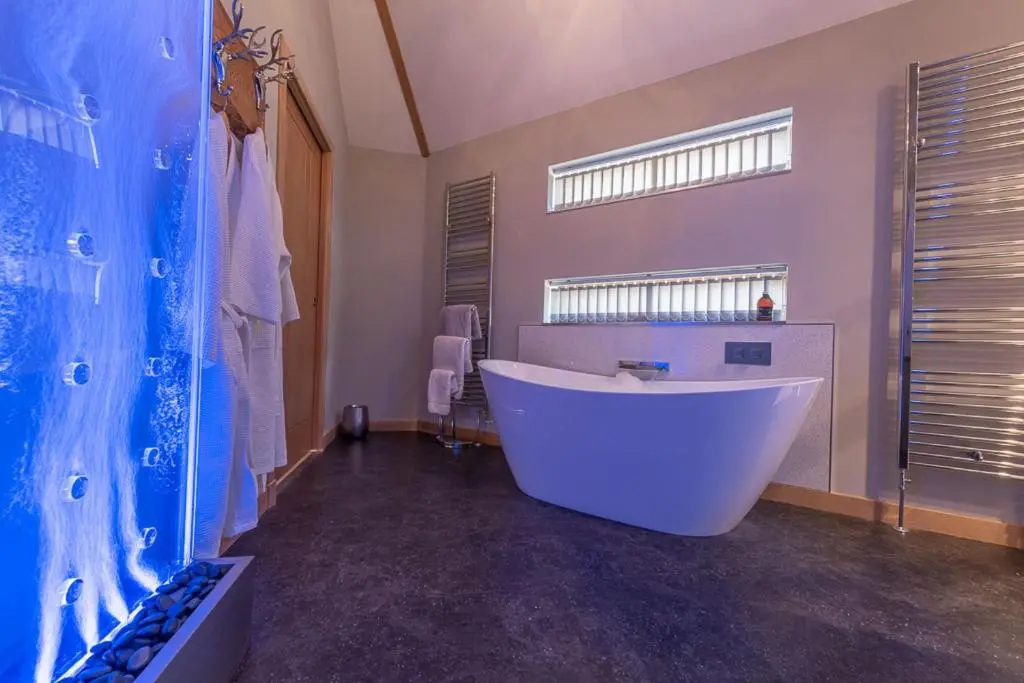 a large bathroom with a large tub and a window at Silver Birch Treehouse in Glenshee