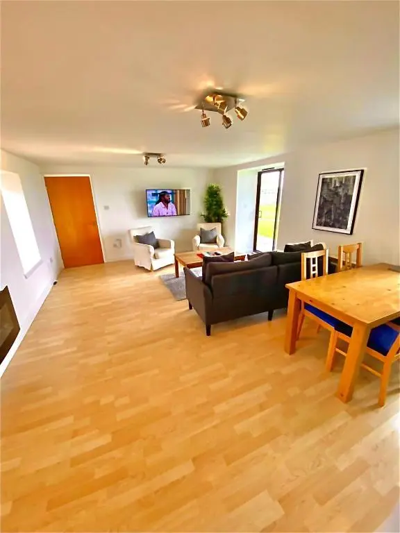 a living room with a couch and a table at Dolphin Bay Suites in Ardersier