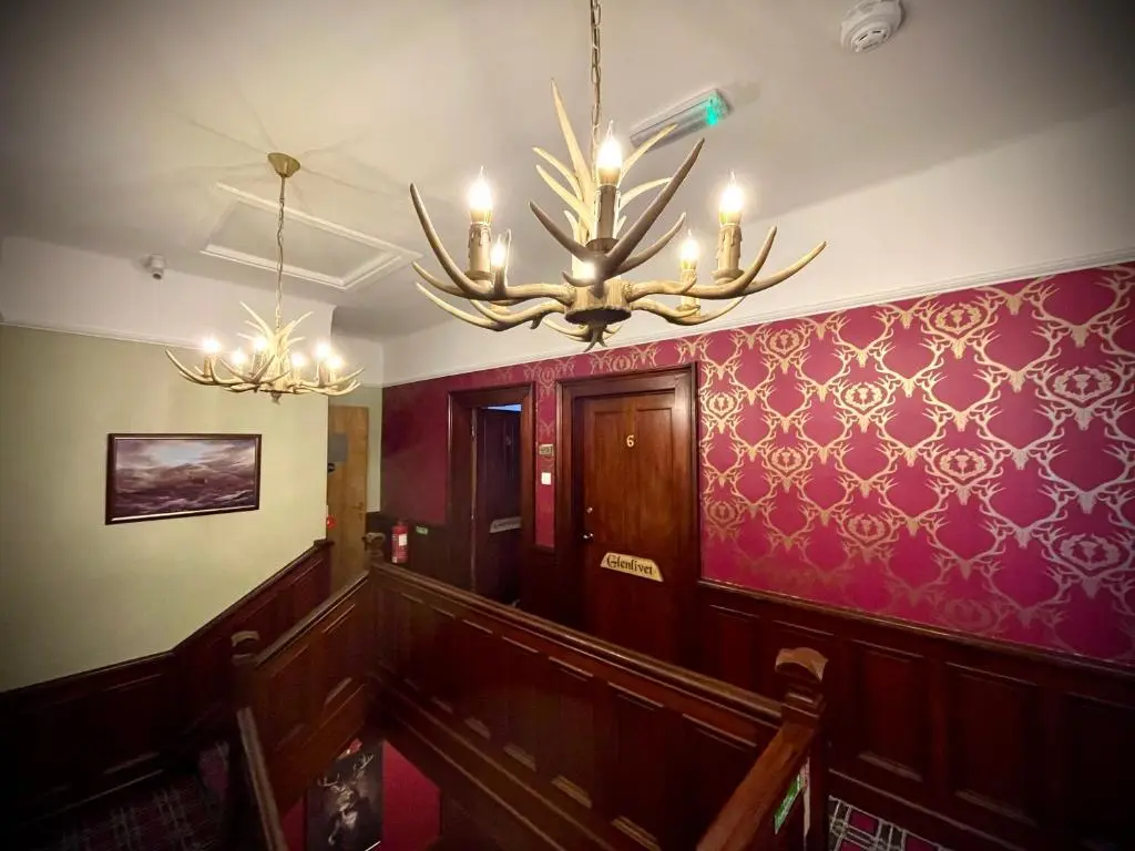 a room with a staircase with a chandelier at Stag and Barrel in Elgin