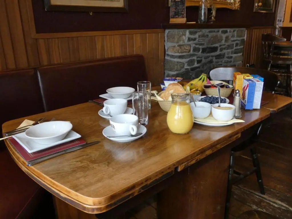a wooden table with cups and dishes on it at Ythanview Hotel