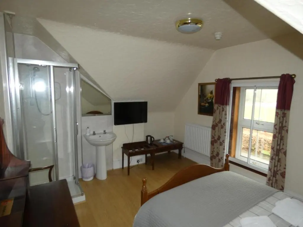 a bedroom with a bed and a sink and a bathroom at Ythanview Hotel