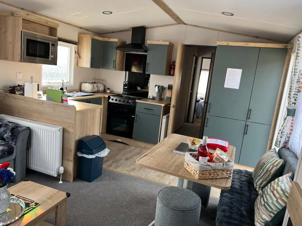 a kitchen and living room with a table and a stove at The Highland Getaway 43 in Boat of Garten