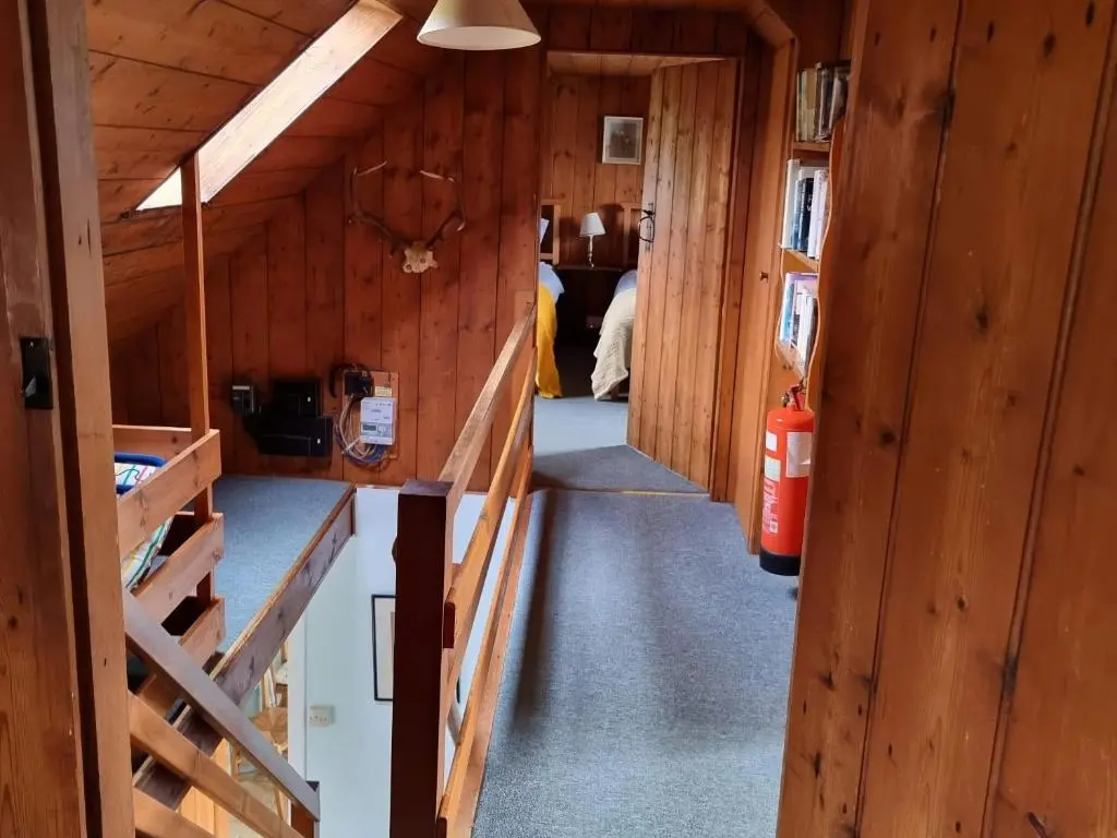 a hallway in a log cabin with a fire extinguisher at Strathnoon in Inverness