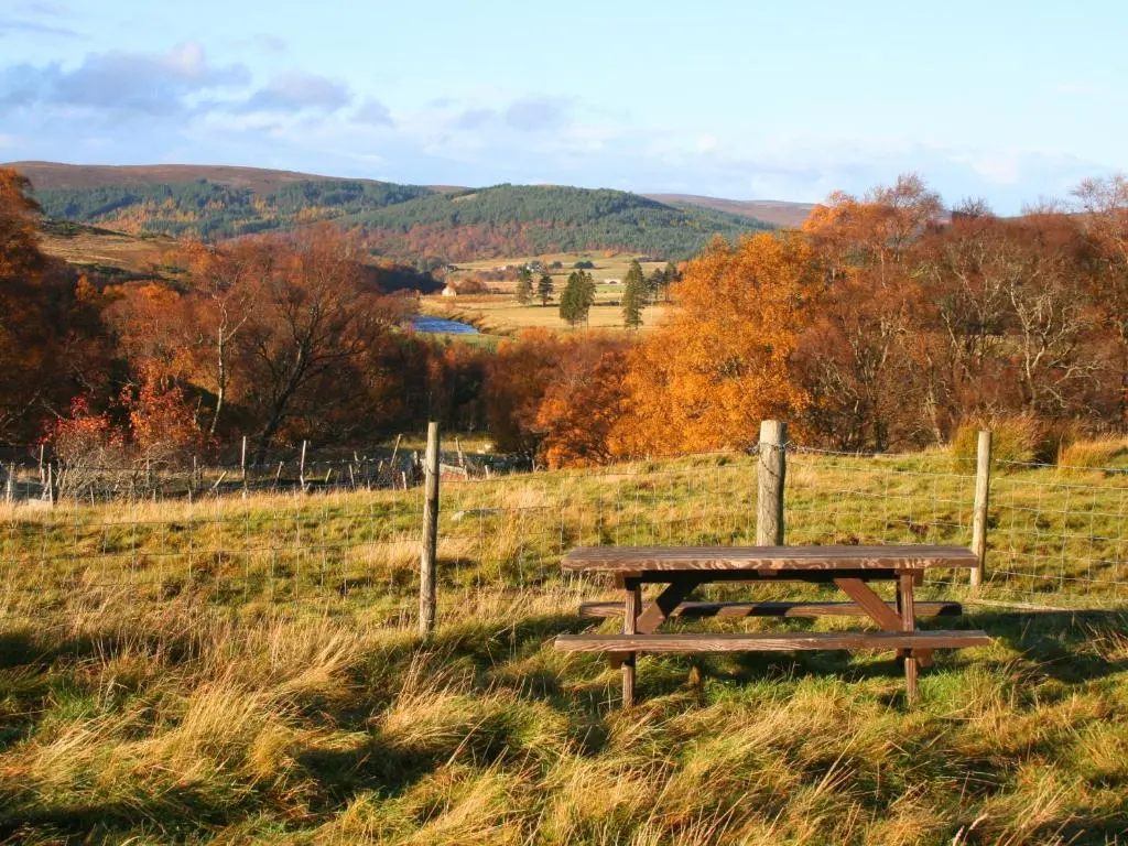 a wooden picnic table sitting in a field at Strathnoon in Inverness