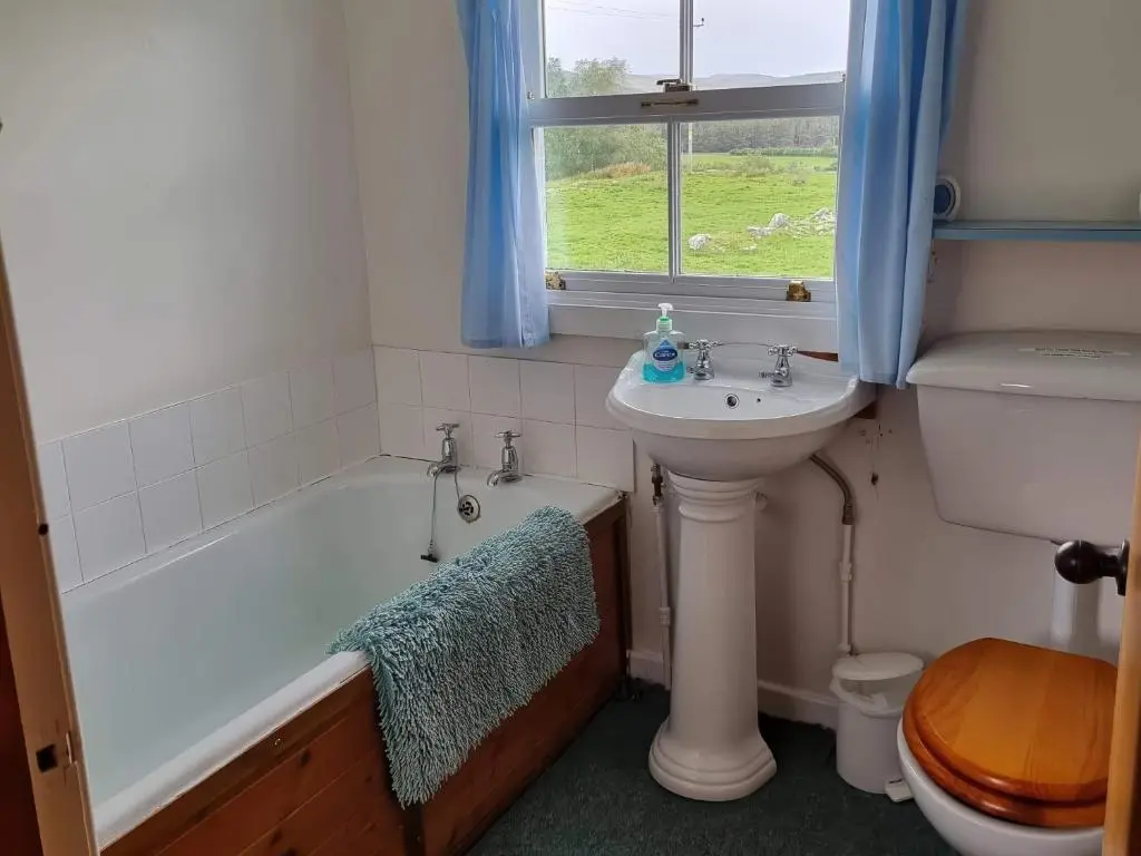 a bathroom with a tub and a sink and a toilet at Strathnoon in Inverness