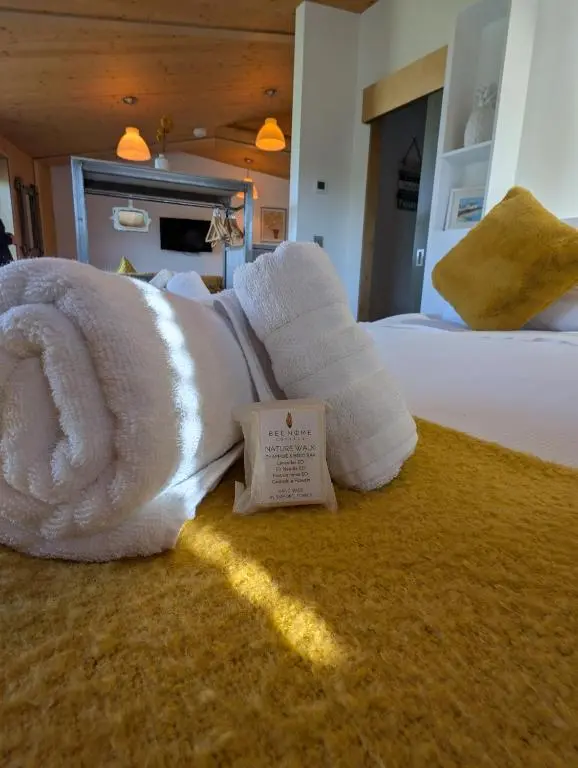 a pile of towels on a bed in a bedroom at Modern Eco-Lodges near Findhorn Beach in Findhorn