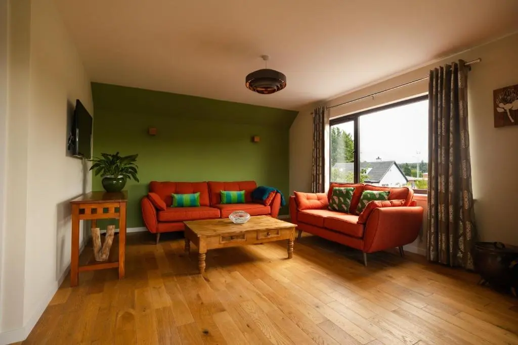 a living room with two red couches and a table at Caledonian View House in Dalneigh