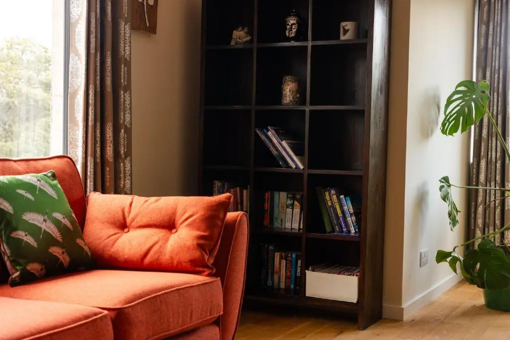 a book shelf filled with books next to a couch at Caledonian View House in Dalneigh