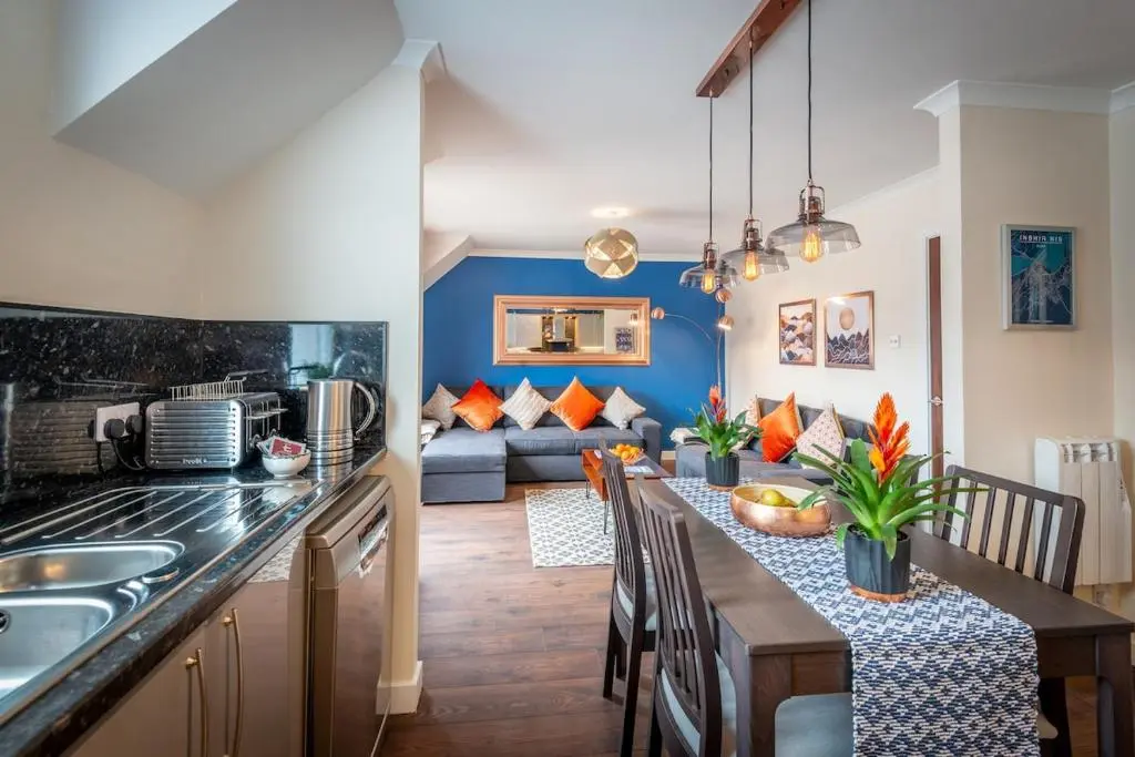 a kitchen and living room with a table and a couch at An I\u00f9bhrach in Inverness