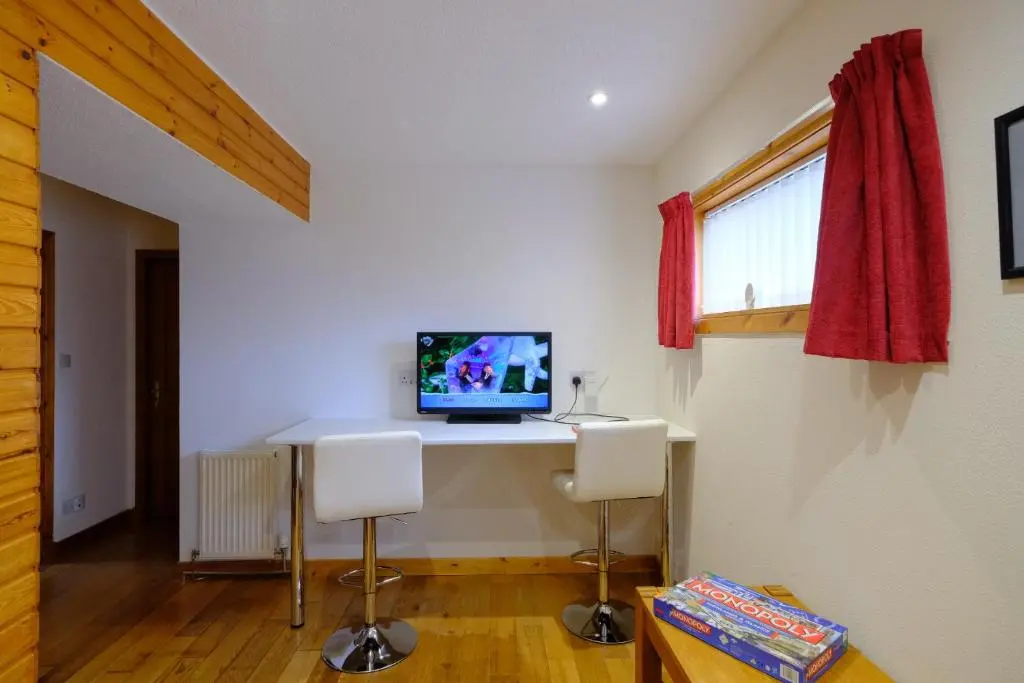 a room with a desk with a computer on it at Suilven Cottage in Tain