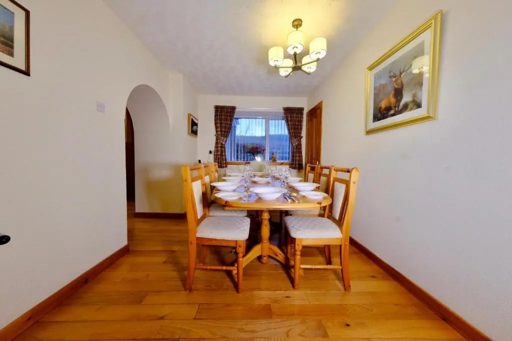 a dining room with a table and chairs at Suilven Cottage in Tain