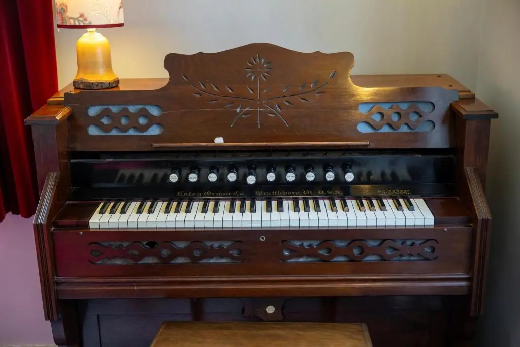 an old organ is sitting next to a lamp at Finest Retreats - White House Retreat in Cornhill