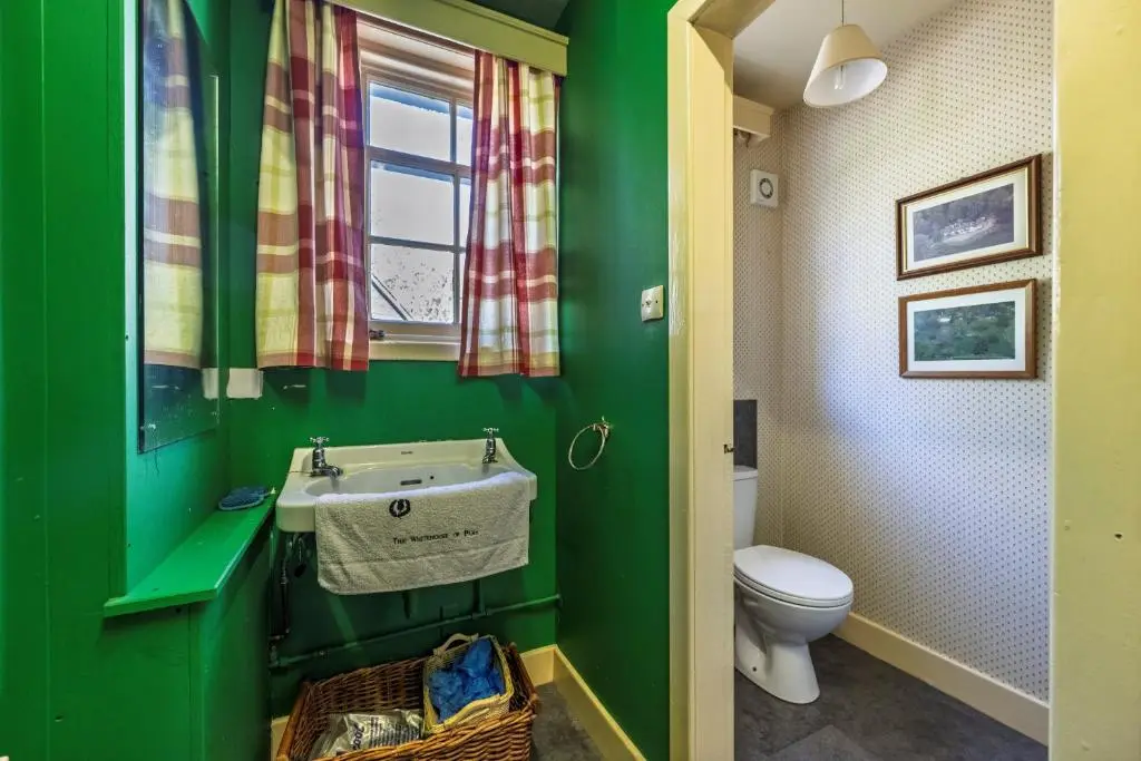 a green bathroom with a sink and a toilet at Finest Retreats - White House Retreat in Cornhill