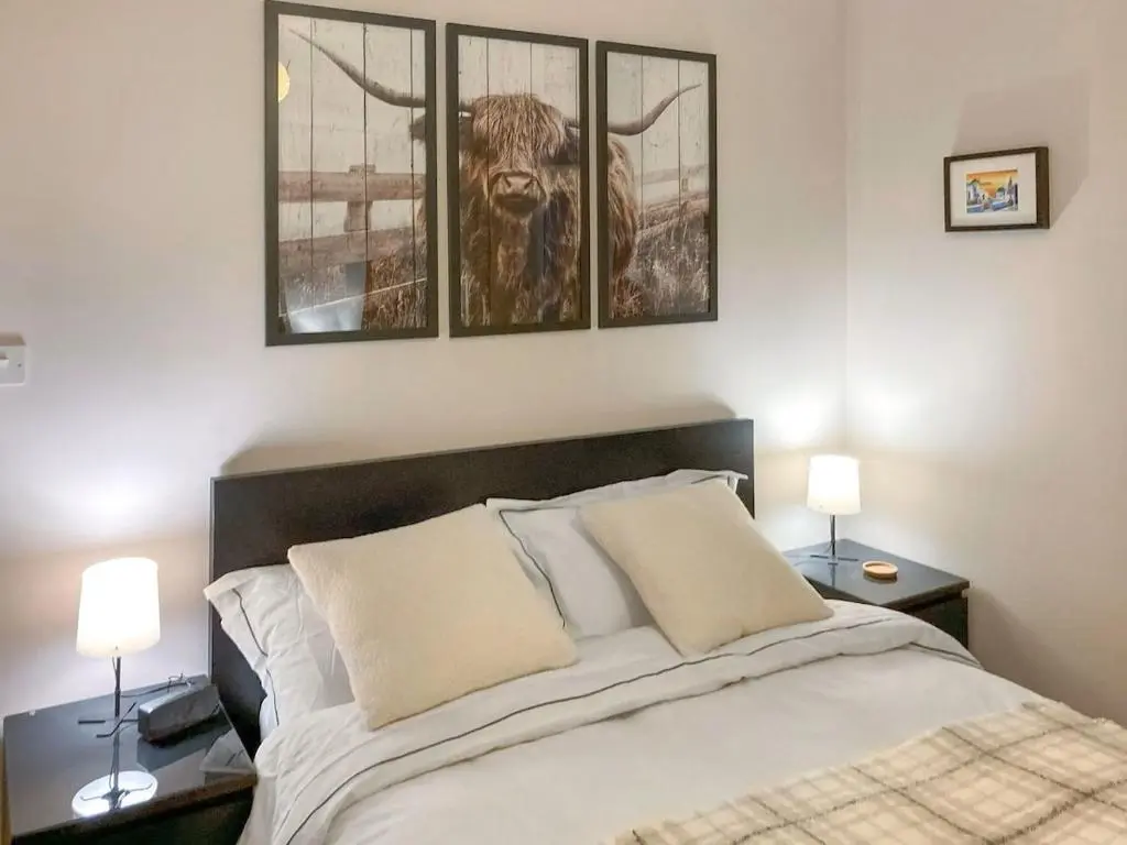a bedroom with a bed with a bull on the wall at Inverness Haven - with Parking and Garden in Dalneigh