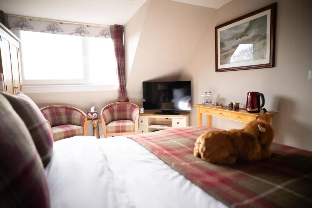 a dog sitting on a bed in a bedroom at Royal Apartment in Inverness