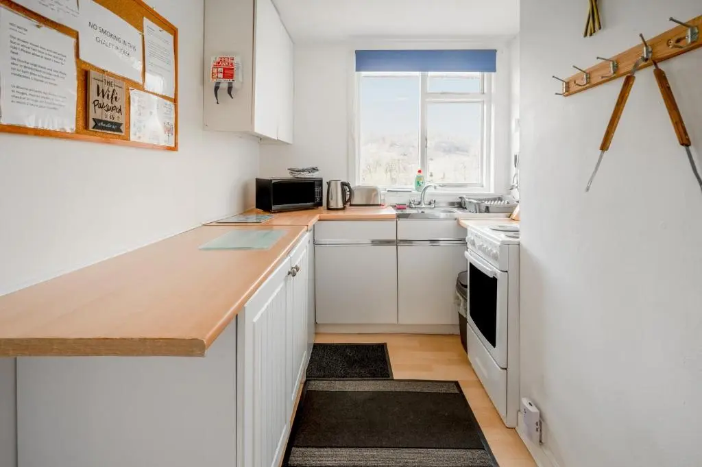 a kitchen with white cabinets and a counter top at 2 Bed Chalet - Sleeps 3 - River and mountain views in Strathpeffer