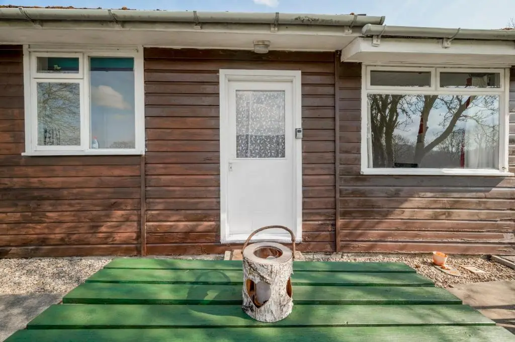 a house with a front door with a tire in front at 2 Bed Chalet - Sleeps 3 - River and mountain views in Strathpeffer