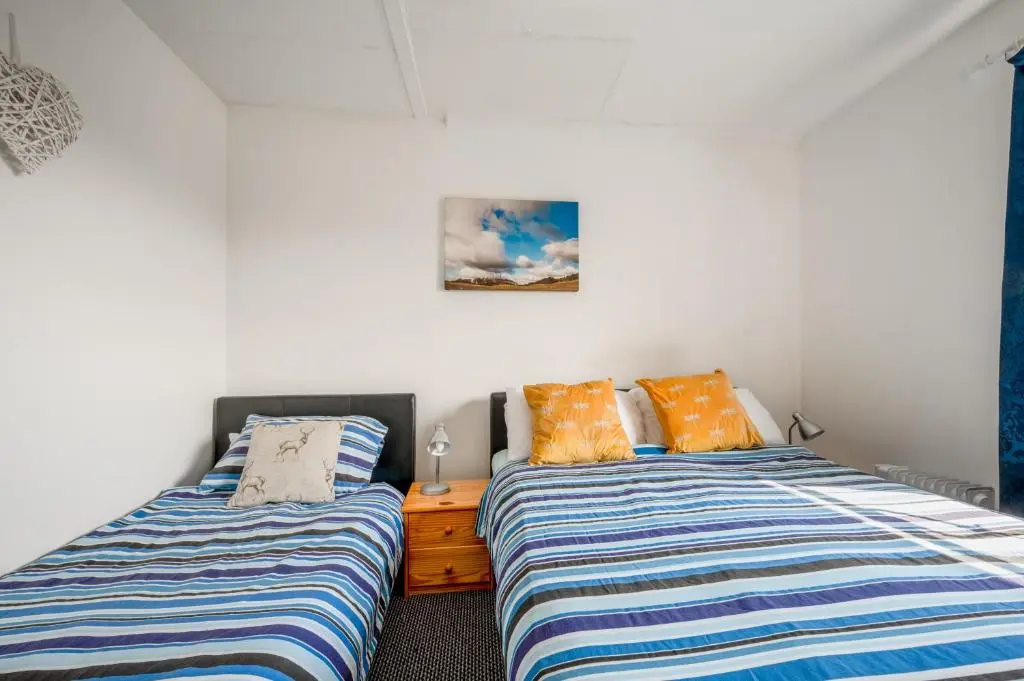 two beds sitting next to each other in a bedroom at 2 Bed Chalet - Sleeps 3 - River and mountain views in Strathpeffer