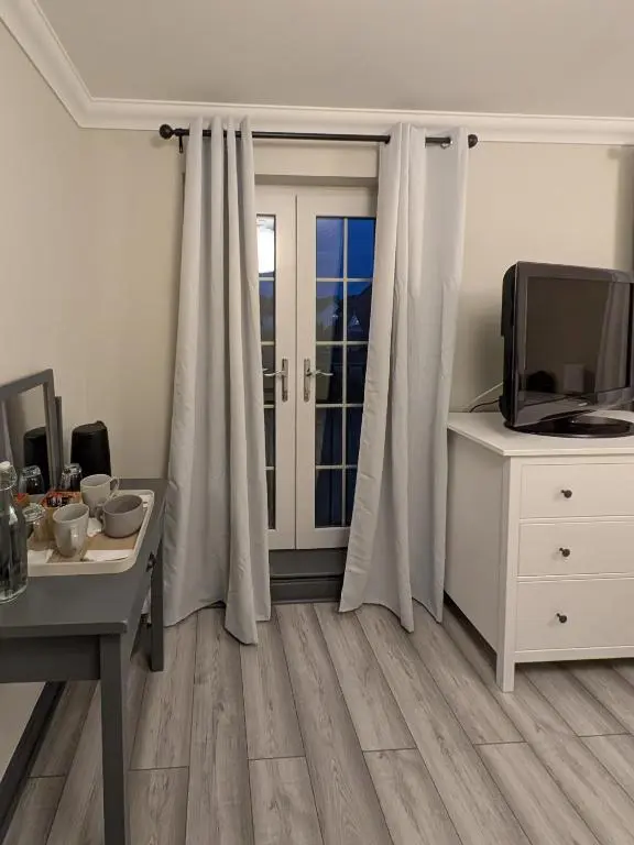 a room with a desk and a tv and a table at Woodgrove Holiday Homes in Inshes