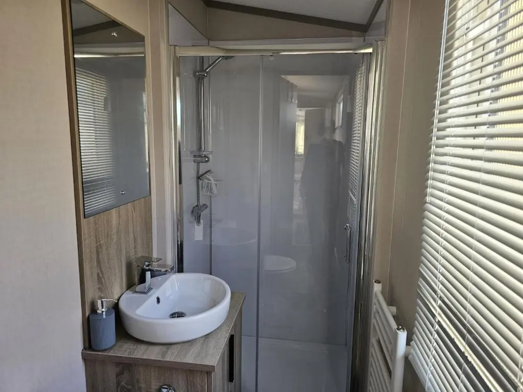a bathroom with a white sink and a shower at Monash in Aviemore