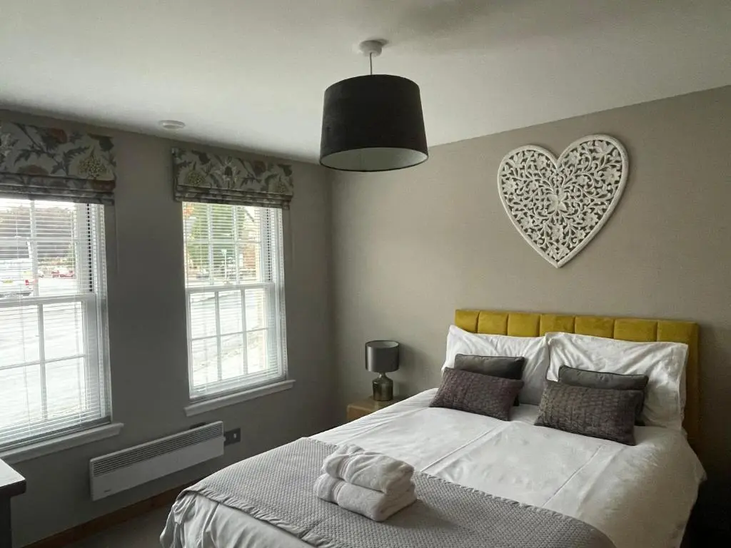 a bedroom with a bed with a heart on the wall at The Town House in Dornoch