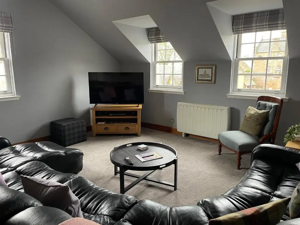 a living room with a couch and a tv at The Town House in Dornoch