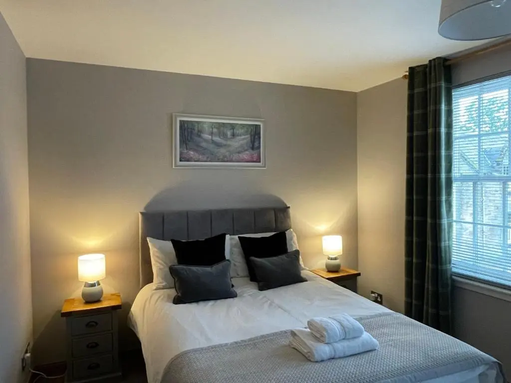 a bedroom with a large bed with two lamps at The Town House in Dornoch