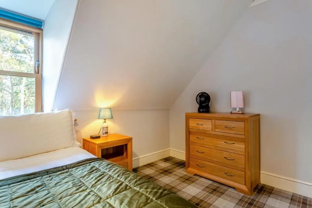 a bedroom with a bed and a dresser and a window at 3 Bed in Huntly oc-g31733 in Huntly