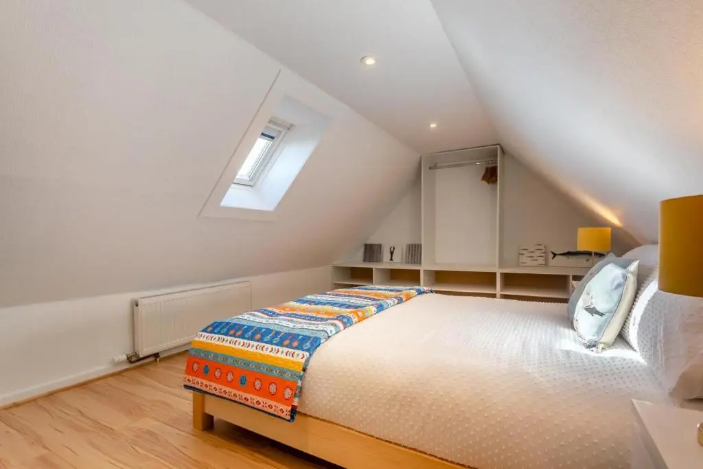 a attic bedroom with a bed and a window at 3 Bed in Avoch oc-c31805 in Avoch
