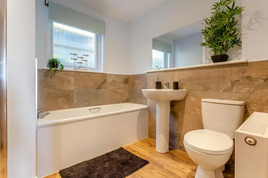 a bathroom with a toilet and a bath tub and a sink at 3 Bed in Avoch oc-c31805 in Avoch