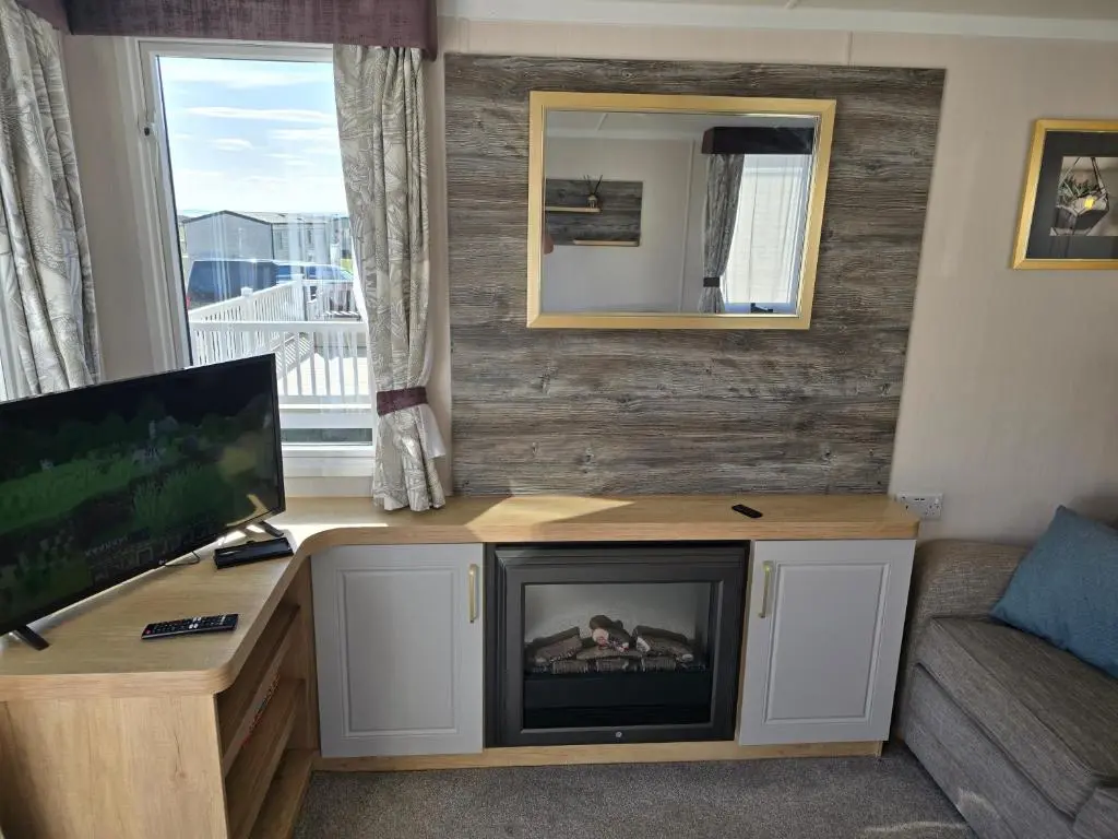 a living room with a tv and a fireplace at 3 Bed-Sleeps 8-Free Parking-5 Min to Beach in Dornoch