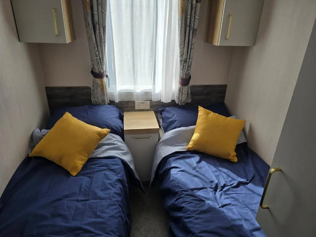 two beds in a small room with a window at 3 Bed-Sleeps 8-Free Parking-5 Min to Beach in Dornoch