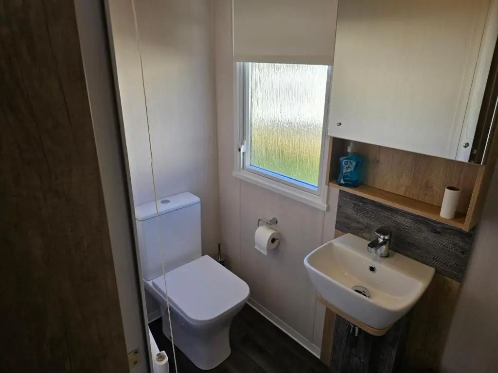 a small bathroom with a toilet and a sink at 3 Bed-Sleeps 8-Free Parking-5 Min to Beach in Dornoch