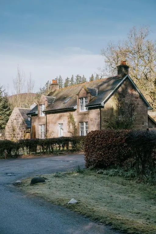 an old stone house with a fence in front of it at Gamekeeper's Cottage in Banchory