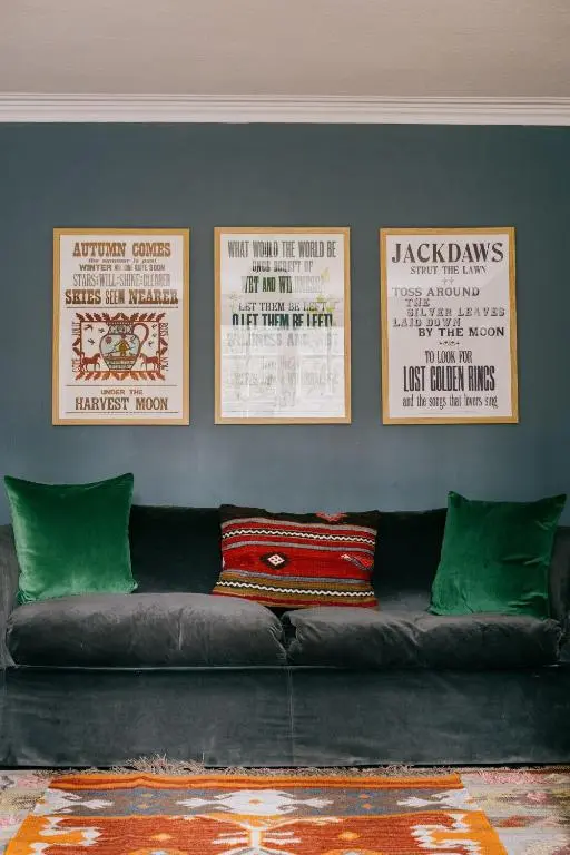 a couch sitting in a living room with three pictures on the wall at Gamekeeper's Cottage in Banchory