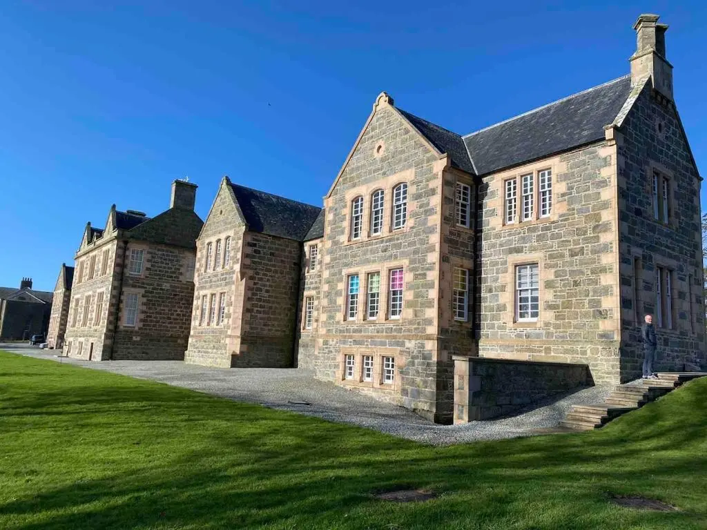 a large brick building with a grass yard at 2 bedroom Townhouse within Grade C listed Ladysbridge House 2 night minimum stay in Ladysbridge Station